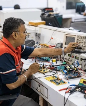 A Motwane R&D engineer testing circuit boards on a lab bench